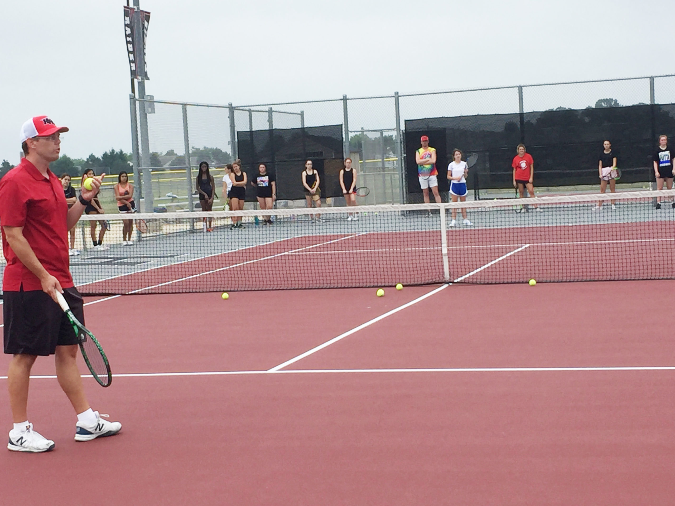 Girls tennis Coach Barry Wells starts a drill in front of about 45 team members at Huntley High School, on Monday, Aug. 10. social distancing around the court. Wells doesn’t think the new rules dictated by concerns over spreading COVID-19 will have much impact on a sport where contestants play apart from each other and the fan base is mostly family members of the players.