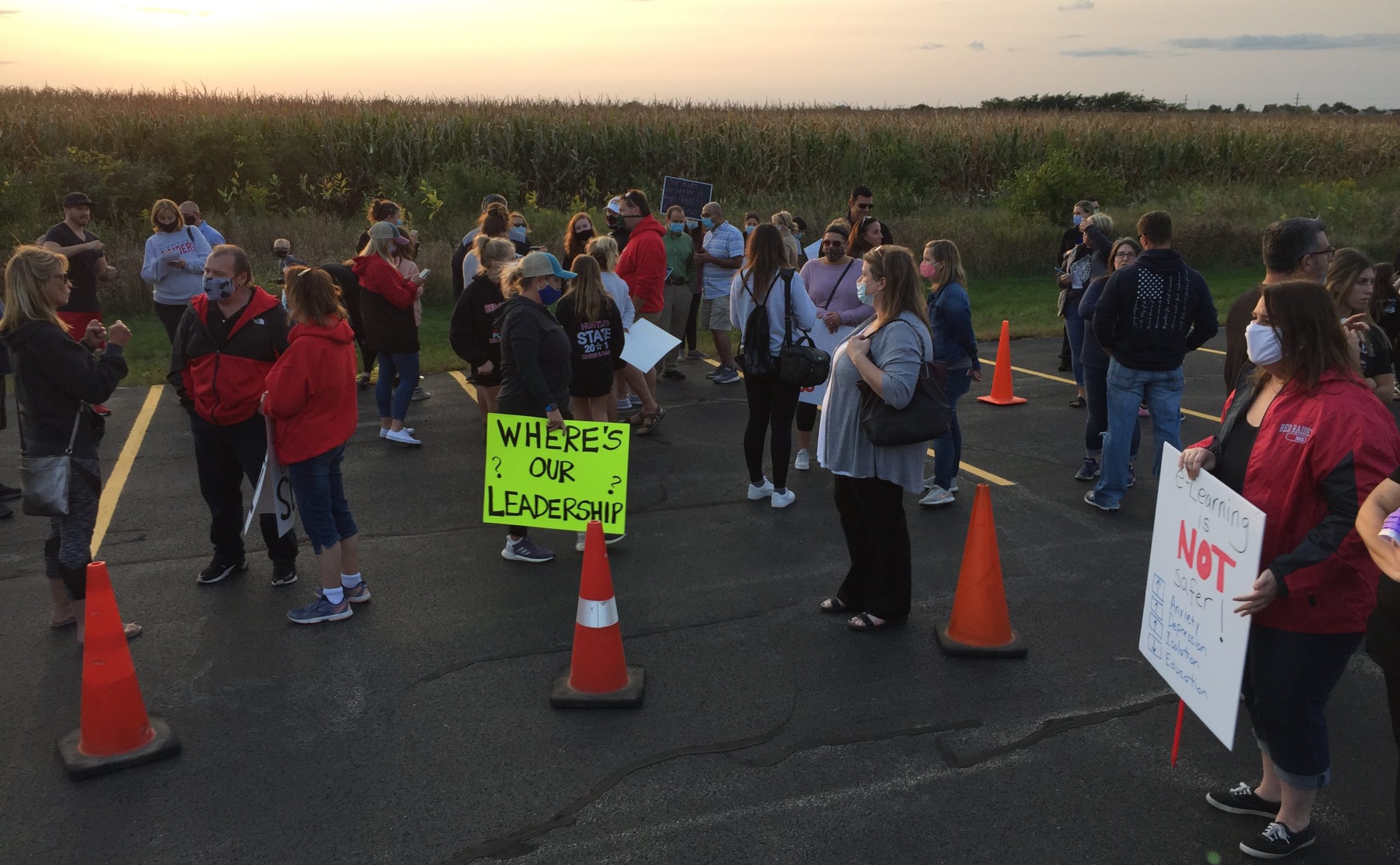 Parents gather outside the Huntley Community District 158 administration building Thursday evening before a meeting where administrators unveiled a plan to have elementary students return to the classroom part-time starting Oct. 19. Students in middle school and high school would continue with remote learning.