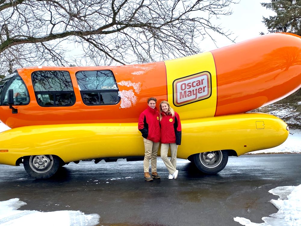 Hotdoggers Zach Chatham and Katie Ferguson pose outside of the Oscar Mayer Wienermobile