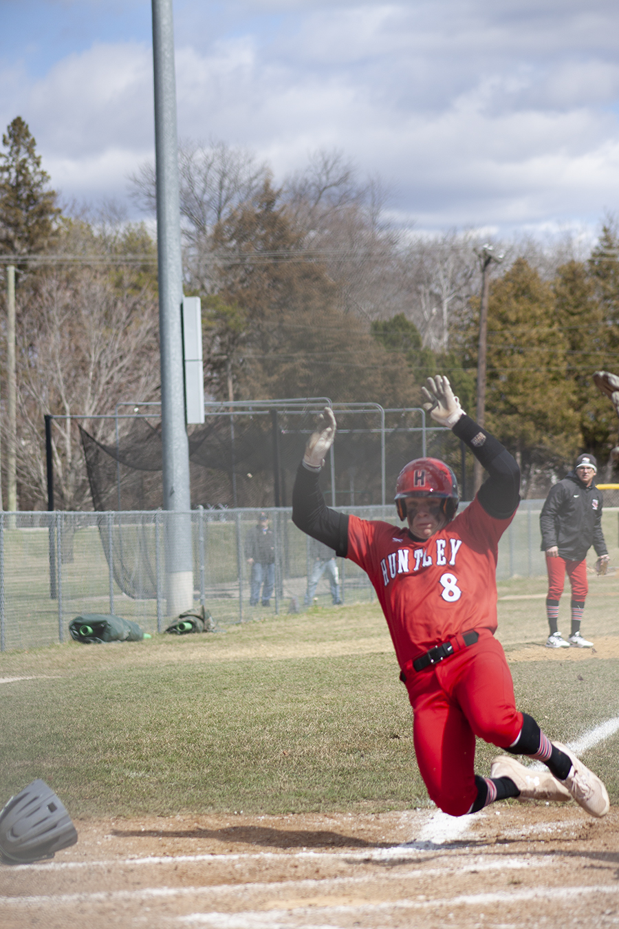 Brayden Bakes slides at home plate against McHenry April 9. The Red Raiders won 7-5 in Fox Valley Conference action.