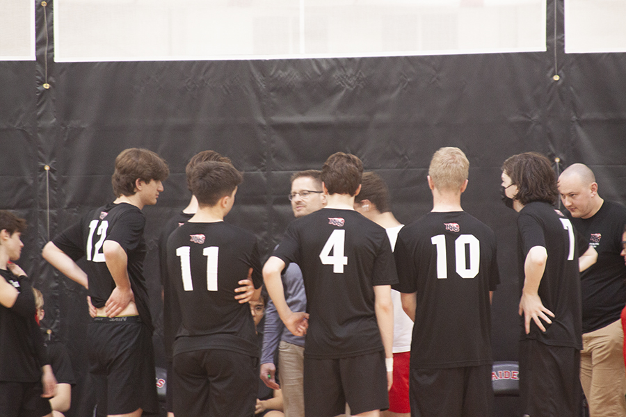 Huntley boys volleyball players listen to head coach Gerard Marchand during a timeout.