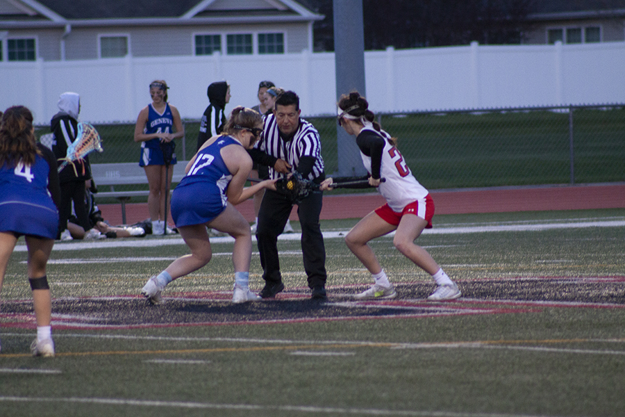 Huntley girls lacrosse's Allie Ambrogio, right, battles a Geneva opponent.