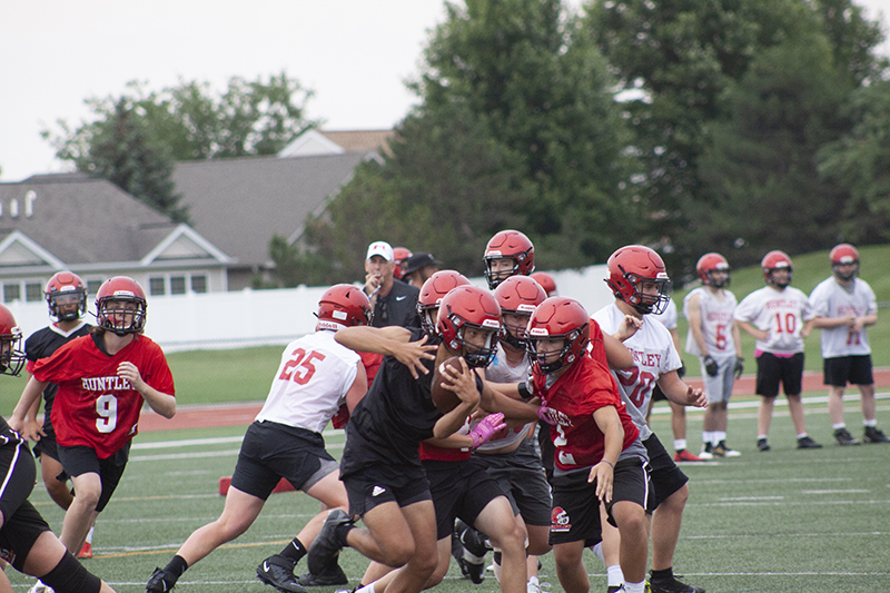 Huntley sophomore quarterback Braylon Bower carries the football and tries to elude the grasp of sophomore defender Chuck Condon. HHS football summer camp resumed July 11.