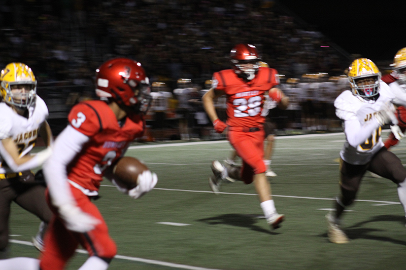 Huntley's Will Kenner seeks yardage against Jacobs and Dylan Melco readies to block. The Red Raiders beat Jacobs, 37-20, Sept. 23 at Red Raider Stadium.