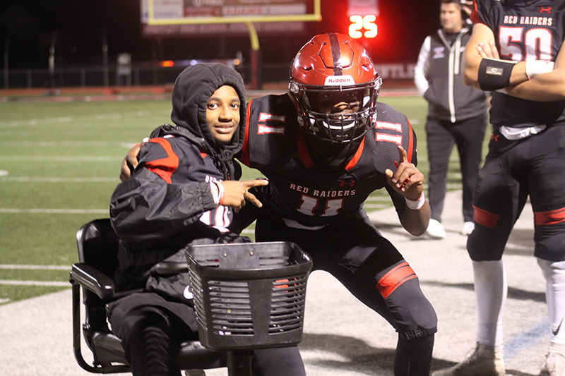 Red Raiders junior Bryce Walker, left, is greeted on the HHS sideline by senior Dashaun Manning Oct. 7 at the HHS homecoming.