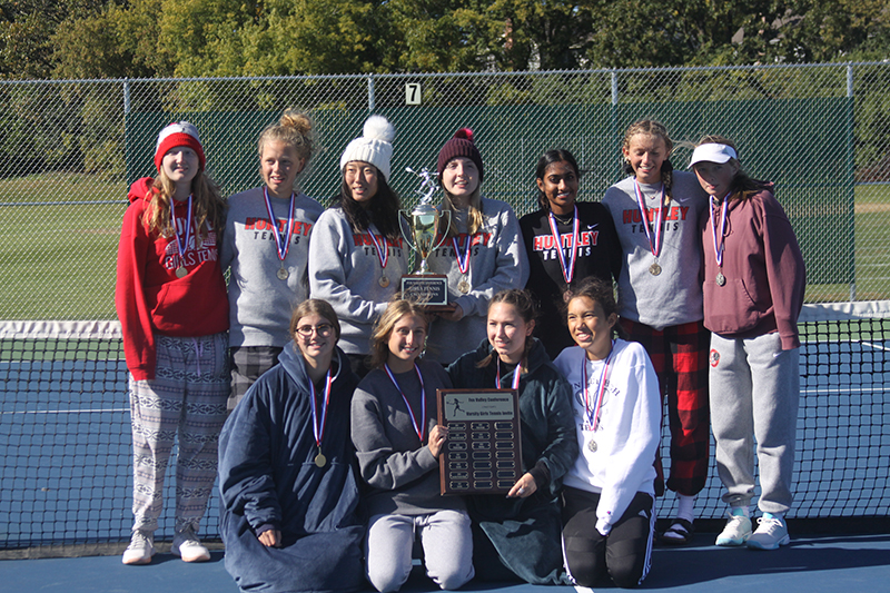 Huntley girls tennis team celebrates its Fox Valley Conference tournament championship. The Red Raiders were also 8-0 in FVC duals, 17-2 overall. Front row from left to right: Delaney Stock, Ellie Pauwels, Julie Klockner and Ashley Phommasack. Second row from left to right: Nora Stevenson, Carie Weishaar, Emily Chong, Ari Patel, Kate Burkey and Ella Doughty.