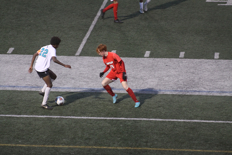 Huntley senior Hunter Hall, right, battles a Woodstock North player for control of the ball Oct. 13. The Red Raiders concluded home matches with a 6-0 victory.