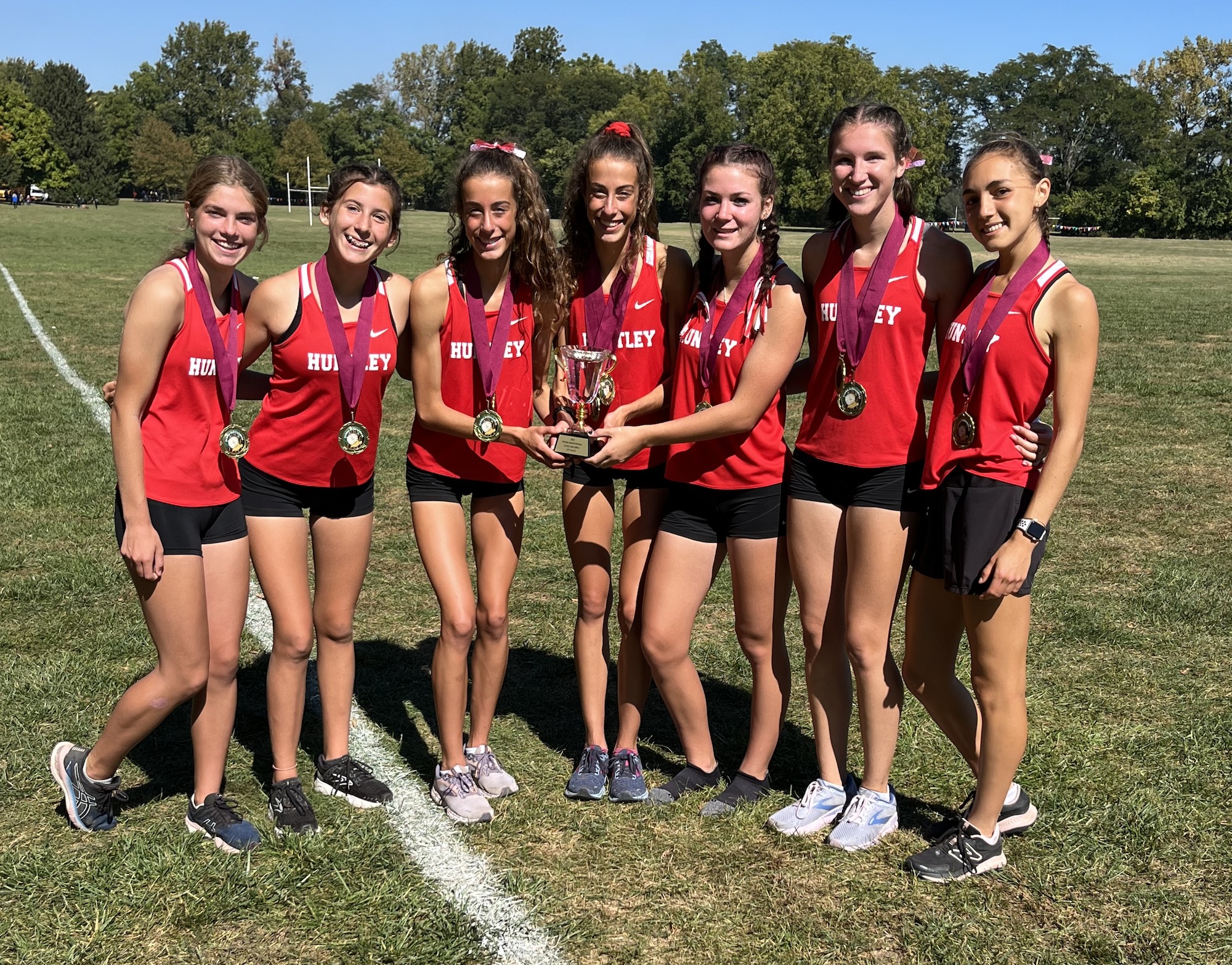 Huntley girls cross country team celebrated a championship at the Peoria Invite Oct. 1. From left: Aspen Malonado, Gabby Sweeney, Brittney Burak, Breanna Burak, Ava Allison, Molly Allen and Guille Gimenez Canet. 