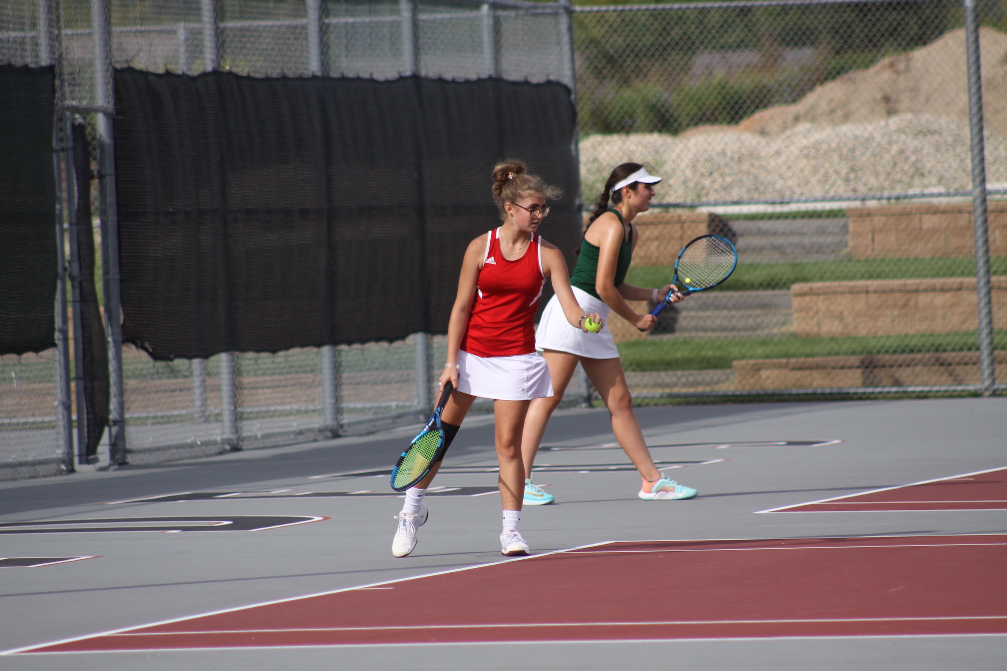 Huntley's Delaney Stock prepares to serve in a second doubles match. She teams with Emily Chong.