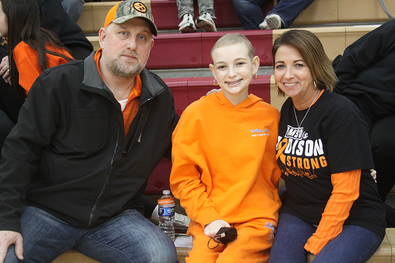 The Roberts family looks on at the Huntley Toss a Duck fundraiser Jan. 13 held during halftime of the boys basketball game. From left. Dad Steve, Madison Roberts and mom Laura. Madison, a freshman at HHS, is battling leukemia.