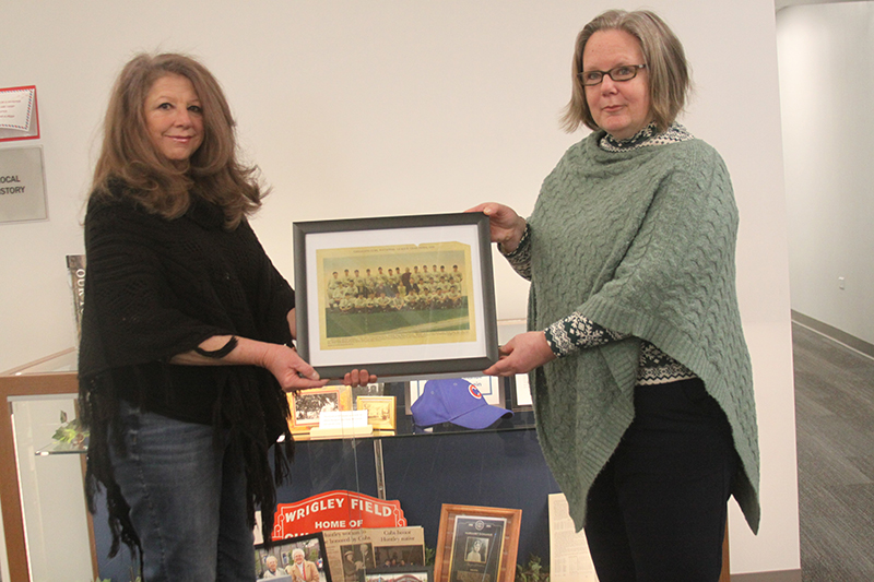 Regina Manning, left, and Andrea Manning, show a display honoring the late Chicago Cubs executive Margaret Donahue, at Huntley Area Public Library. The display also includes information on pro baseball player Johnny Klippstein, who lived in Huntley.