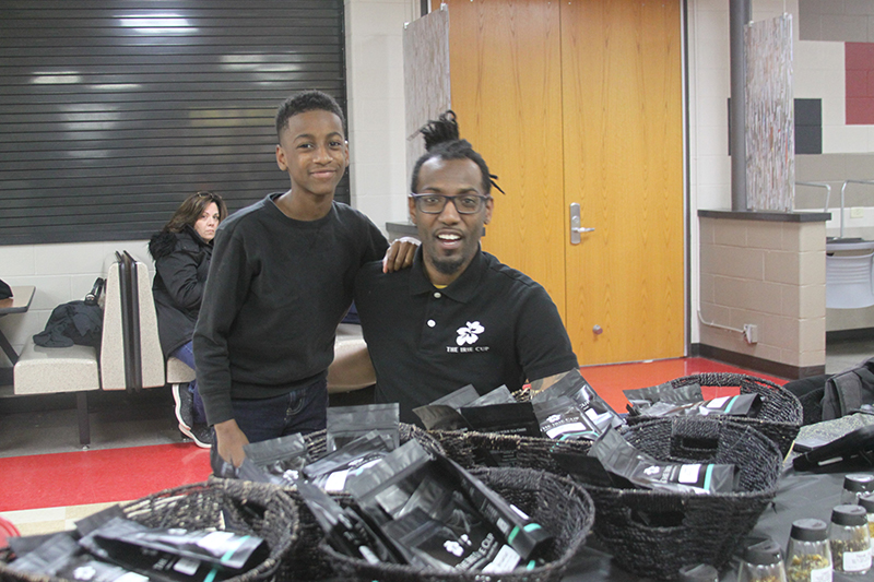 Sam Lewis, left and Joe Lewis, show off teas from “The Irie Cup” in Huntley. They participated in the Recognizing American Diversity (RAD) event Feb. 24 at Huntley High School.