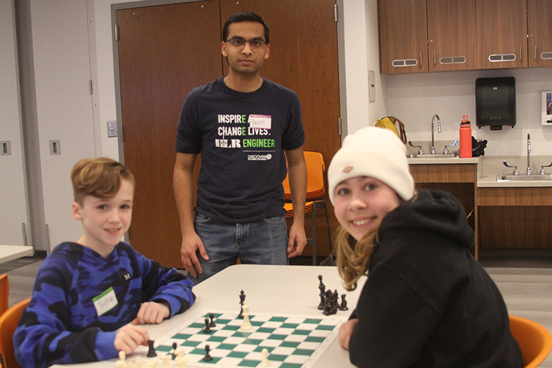 Chess Club players Tristian Baum, left and Summer Milostan play a game of chess as organizer Anish Bhatt looks on at Huntley Area Public Library.