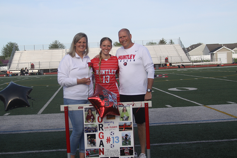 Huntley senior girls soccer players celebrated senior night May 9. From left, Becky, Morgan and Kyle McCaughn. Kyle is the head girls coach for Crystal Lake South. The Red Raiders beat the Gators 5-0.