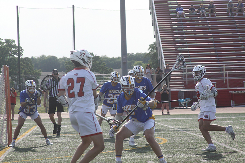 Huntley junior Nico Andrews (27) battles with a Lake Forest player at the Huntley super-sectional May 30. Justin Jacobsen (6) is ready to get a shot on goal. HHS lost to the Scouts, 12-2.