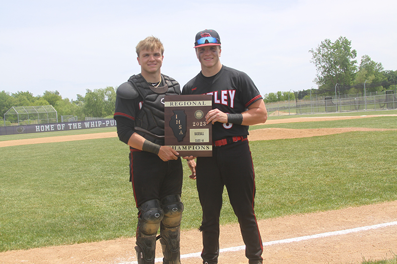 Huntley seniors Ryan Bakes, left, and brother Brayden Bakes hold the Class 4A Hampshire Regional trophy won by the Red Raiders May 27. Ryan played catcher while Brayden played center field.