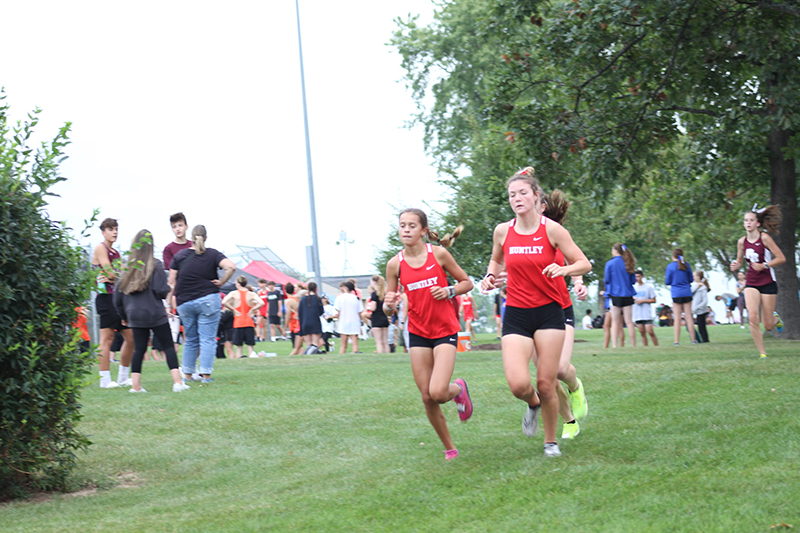 Huntley girls cross country runners, Haley Rahman, left and Ava Allison compete during the McHenry County Cross Country Meet. The Red Raiders won the girls team championship Aug. 26.