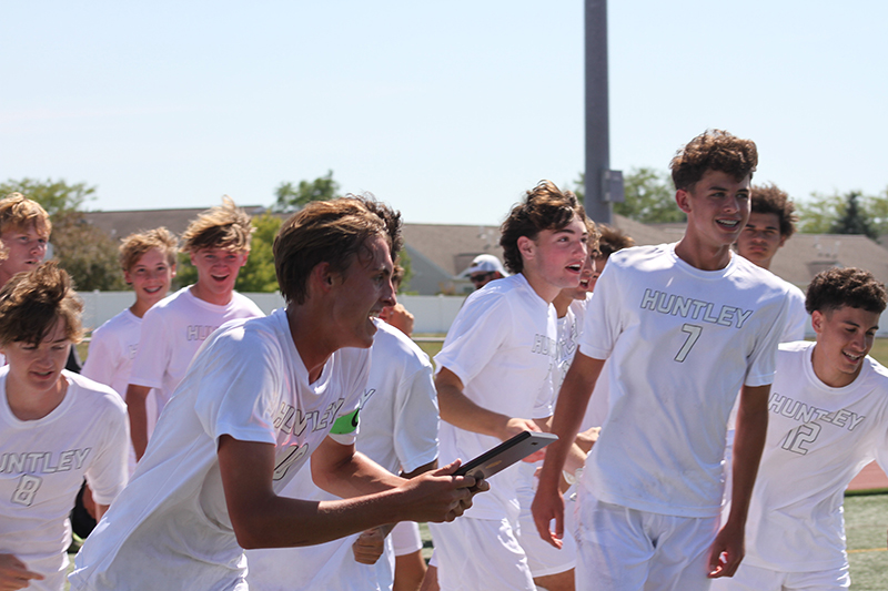 Hudson Nielsen celebrates with the Huntley boys soccer quad tournament plaque earned Sept. 2. Mason Leslie and Isaac Jacobo join in the fun.