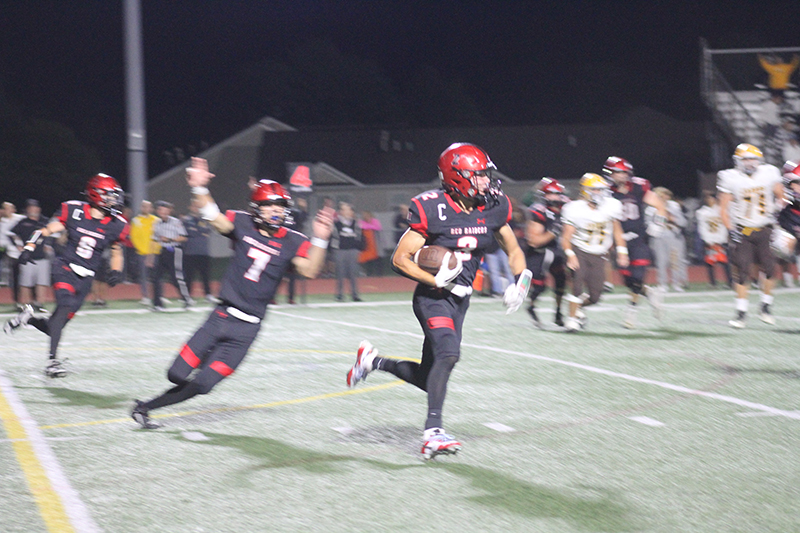 Huntley senior Zack Garifo heads to a touchdown after an interception against Jacobs. Linebacker Ryan Sweeney (7) looks on. Huntley beat Jacobs 41-20 Sept. 8.