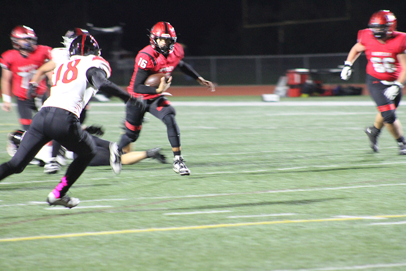 Huntley quarterback Braylon Bower (16) eludes Niles West tacklers. The Red Raiders won the Class 8A first round playoff game, 26-14 Oct. 28.