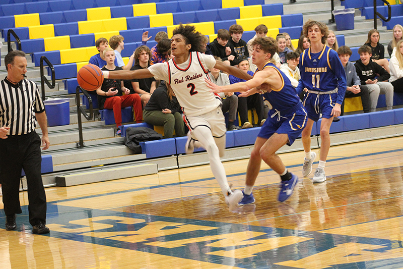 Huntley senior Omare Segarra reaches for a loose ball against Johnsburg. The Red Raiders won the Johnsburg Thanksgiving Tournament championship.