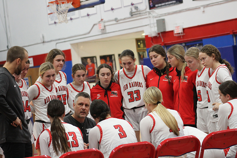 Huntley head girls basketball coach Steve Raethz, center, gives instructions during a timeout in the Red Raiders game against Maine West on Dec. 26. Raethz will be honored as an Illinois Basketball Coaches Hall of Fame inductee in May.