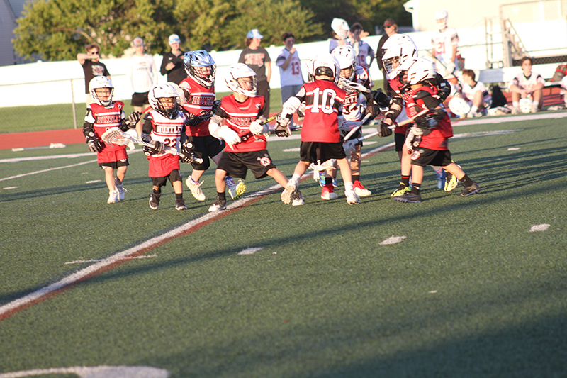 Young Huntley boys lacrosse players do battle during a scrimmage at halftime of a Red Raiders varsity match against Cary-Grove May 10.