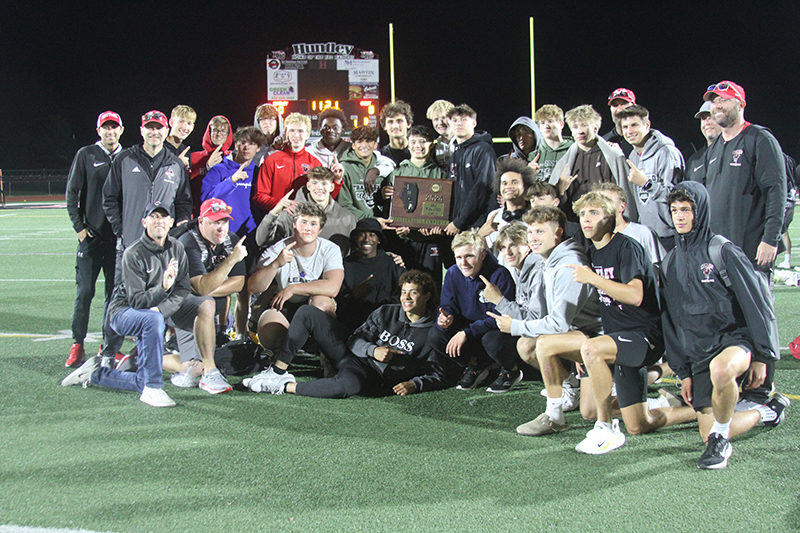 Huntley boys track and field team members and coaches celebrate the squad's IHSA Class 3A Sectional championship.