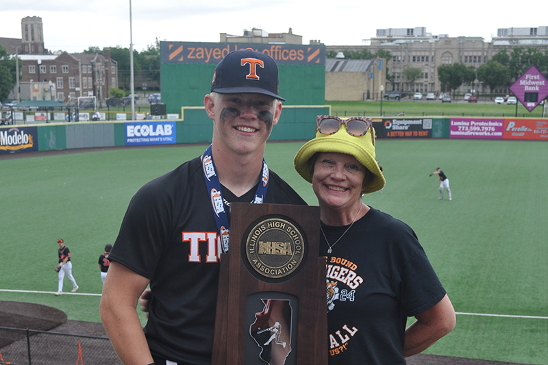 Crystal Lake Central pitcher Tommy Korn, and his mom Jennifer, pose with CLC's Class 3A State Baseball Championship trophy. Jennifer works at Huntley Community School District 158.