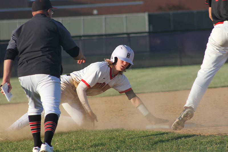 Huntley's Kyle Larson slides to third base with a triple against Barrington. HHS head coach Andy Jakubowski looks on. Huntley won the IHSA Class 4A sectional game 6-3.