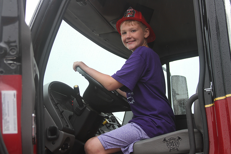 Emmett Larson, age 9, son of Hampshire Fire Department Deputy Chief Eric Larsen, enjoys the view from a fire engine drivers' seat. The Hampshire Fire Protection District hosted a ribbon cutting and open house at its new station June 1.