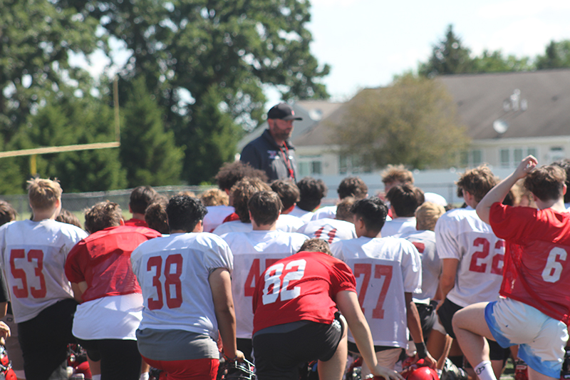 Huntley head football coach Mike Naymola talks to the team after a summer camp session.