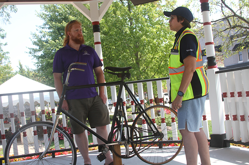 Huntley Historical Society member Jake Marino talked about the Latimer bicycle, which was invented in Huntley, at the Bike Huntley event Aug. 4. Margarita Rehr of Huntley looks on.