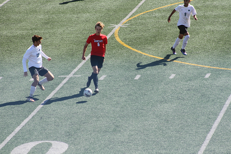 Huntley soccer player Max Bauer heads upfield against Woodstock North.