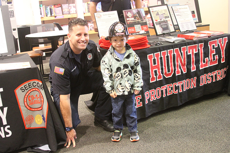 Huntley Area Fire Protection District (HAFPD) firefighter Tim Broderick meets Leo Chanchola, age 3, of Algonquin, at an event at Algonquin Area Public Library.