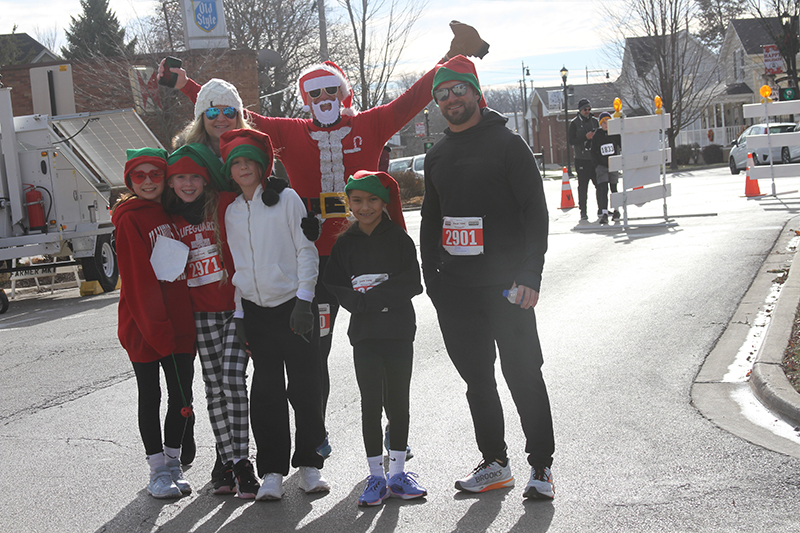 Runners are happy to complete the Rotary Club of Huntley's Run With the Elves. The event was part of Very Merry Huntley Dec. 7. Front row from left: Evelyn Jones, Shaya Speten, Alyssa Armstrong, and Aria Armstrong. Back row: Tami Speten, Shane Speten, and Phillip Armstrong.