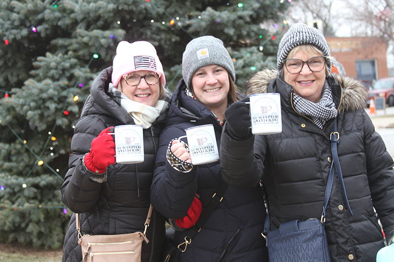 Participants at the Huntley Area Chamber of Commerce's Ice Sculpture Cocoa Crawl event raise their mugs of cocoa at the village Christmas tree. From left: Kathleen Rezendes, Irene Myers and Sheila Klaratos.