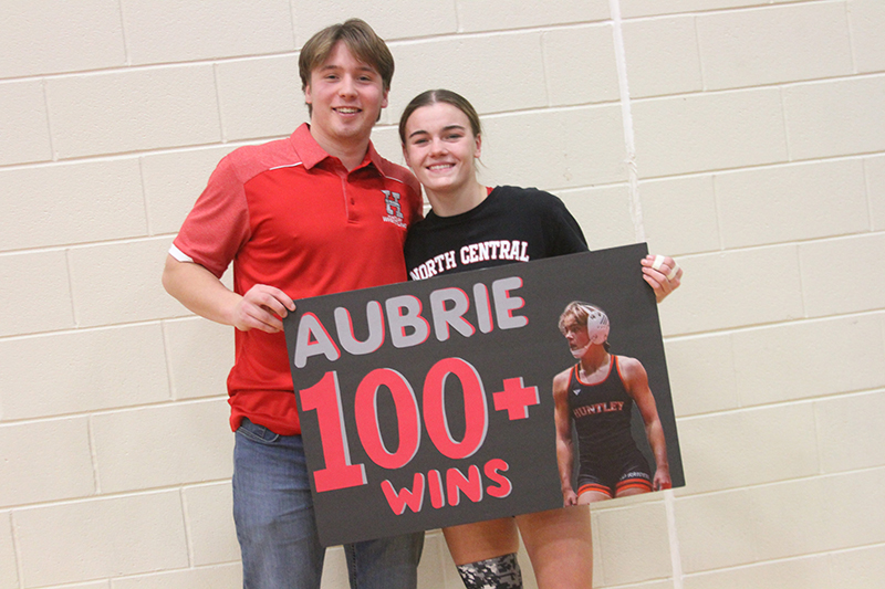 Huntley girls wrestling coach Gannon Kosowski, left, congratulates Aubrie Rohrbacher on winning her 100th match.